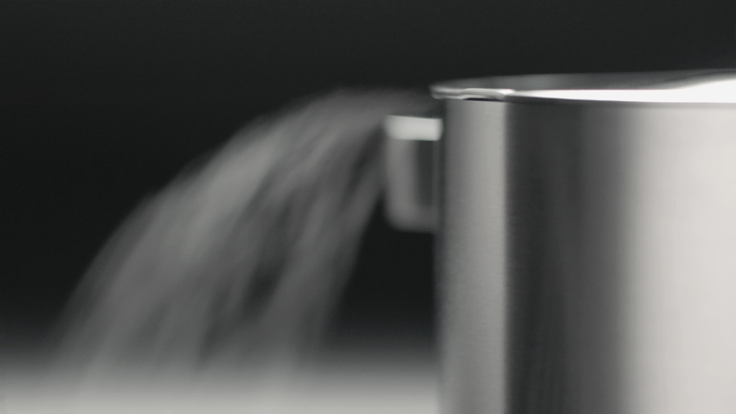 Steam rising from a pot on an integrated cooktop with ventilation.